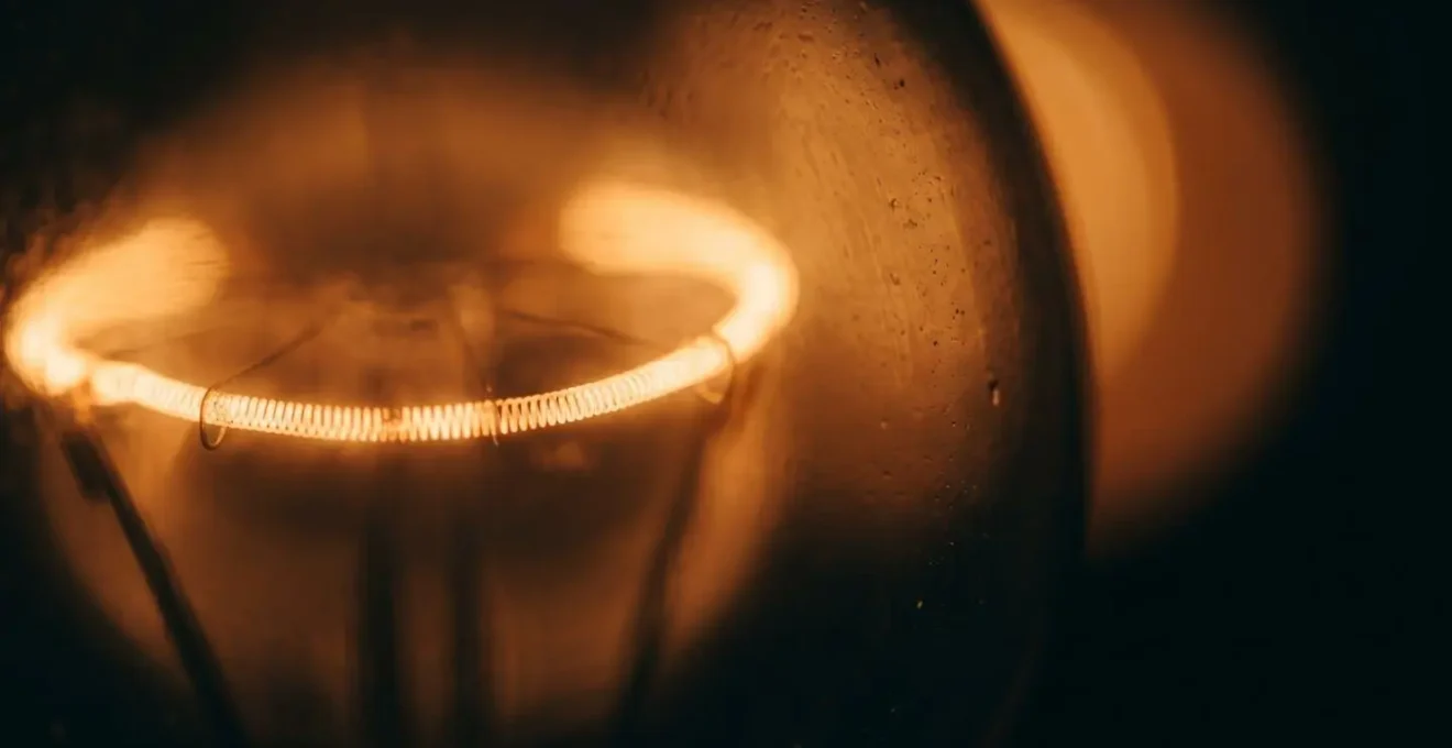 Détail macro d'une source lumineuse chaude diffusant une lumière ambrée douce dans l'obscurité, illustrant le spectre optimal pour favoriser le sommeil