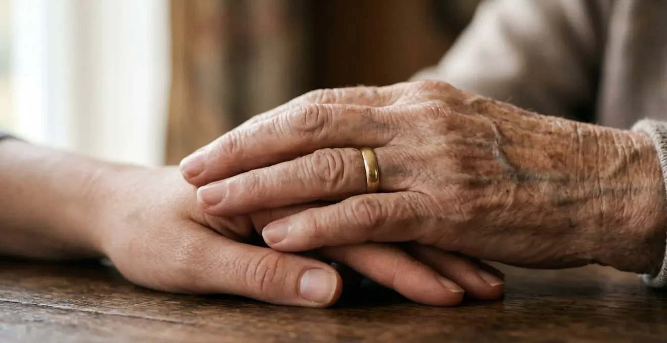 Gros plan sur deux mains se touchant avec douceur, évoquant le lien intergénérationnel et le soutien empathique